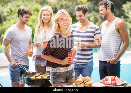 Gruppo di amici preparando per esterni barbecue party Foto Stock