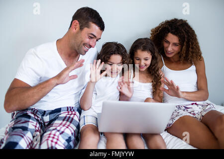 Famiglia avente la video chat su laptop Foto Stock