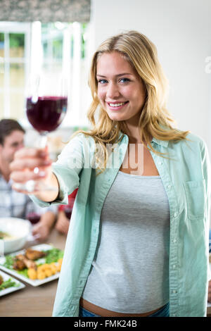 Ritratto di donna felice offerta di vino rosso Foto Stock