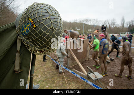 Bischofsheim, Germania. Xii Mar, 2016. Partecipante delle condizioni estreme di eseguire Braveheart battaglia salendo un ostacolo in Bischofsheim, Germania, 12 marzo 2016. Quasi 2.700 corridori hanno la necessità di gestire un 30 chilometro via con 45 ostacoli. Il extremerun conduce attraverso acqua ghiacciata, profonde buche di fango e di fuoco caldo ostacoli. Si è detto di essere uno tra i più duri in Europa. Foto: DANIEL KARMANN/dpa/Alamy Live News Foto Stock