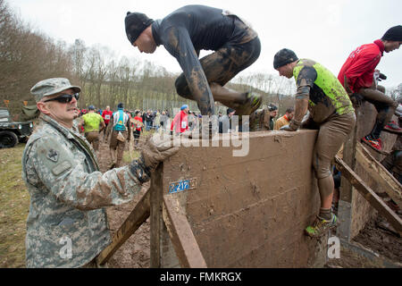 Bischofsheim, Germania. Xii Mar, 2016. Un partecipante di estrema eseguire Braveheart battaglia salendo un ostacolo in Bischofsheim, Germania, 12 marzo 2016. Quasi 2.700 corridori hanno la necessità di gestire un 30 chilometro via con 45 ostacoli. Il extremerun conduce attraverso acqua ghiacciata, profonde buche di fango e di fuoco caldo ostacoli. Si è detto di essere uno tra i più duri in Europa. Foto: DANIEL KARMANN/dpa/Alamy Live News Foto Stock