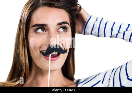 Donna sorridente holding baffi artificiali Foto Stock