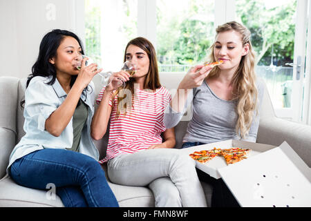 Amici di sesso femminile avente spuntini e bevande a casa Foto Stock