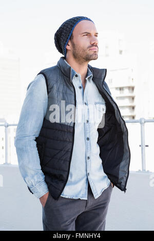 Fiducioso giovane uomo che indossa beanie hat e giacca Foto Stock