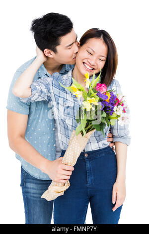 Baciare uomo donna e dando i suoi fiori Foto Stock