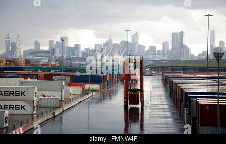 A cavallo di un cestello di trasporto per contenitori in un giorno di pioggia nel porto di Melbourne, Australia. Foto Stock