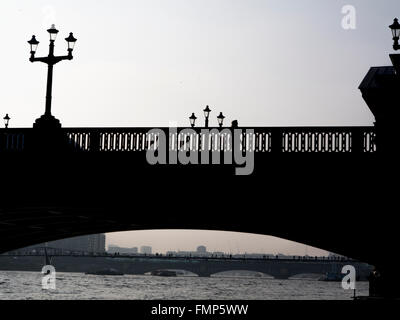 Pendolari a piedi attraverso Blackfriar's Bridge al tramonto con regolazione del sole Foto Stock