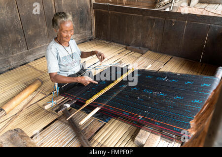 Donna anziana tessitura stoffa ikat mostrando, tradizionale villaggio Ngada Bena, Bajawa, Flores, Indonesia Foto Stock