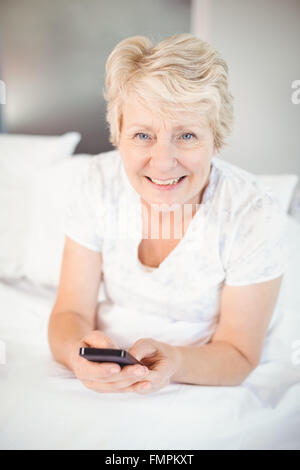 Sorridente donna senior usando il telefono Foto Stock