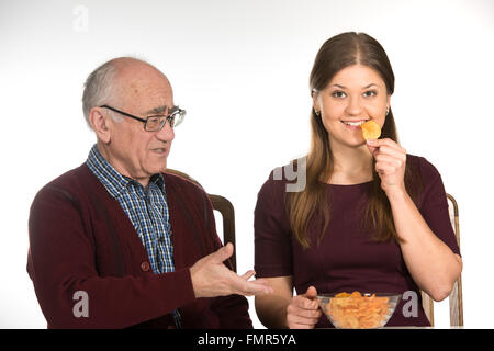 Il vecchio uomo senior e la giovane donna mangiare patatine Foto Stock