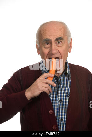 Il vecchio uomo senior di mangiare la carota Foto Stock