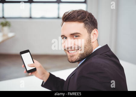 Ritratto di happy businessman utilizzando il telefono cellulare Foto Stock