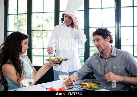 Giovane lamentando il cibo di chef Foto Stock