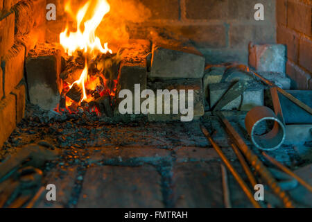 Un fuoco che brucia nel forno l'antica fucina Foto Stock
