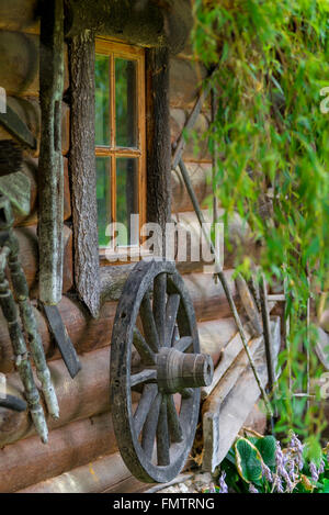 Ruota da un vecchio carrello di legno vicino casa rurale Foto Stock