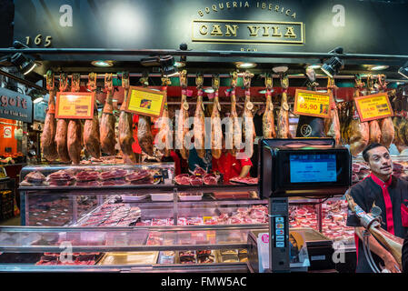 Negozio di carne con prosciutto iberico e jamon bellota dry-prosciutto crudo al Mercat de Sant Josep de la Boqueria mercato, Barcellona, Spagna Foto Stock