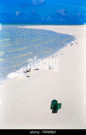 Bottiglia di vetro verde lavata a riva su una spiaggia incontaminata Cook Islands nell'Oceano Pacifico del Sud Foto Stock