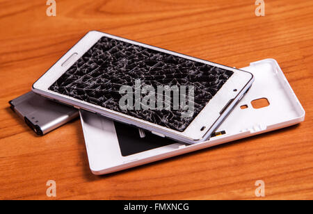 Aperto rotto il telefono cellulare con la batteria sulla massa di legno Foto Stock