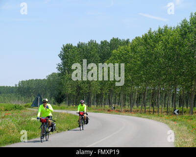 Due cicloturisti a cavallo su una strada di campagna, nord Italia. Foto Stock