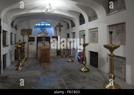 Tombe dei più notevoli persone dell'emigrazione russa in Cecoslovacchia nella cripta sotterranea della Dormizione chiesa presso il Cimitero di Olsany a Praga, Repubblica Ceca. Tombe di Primo Ministro della Cecoslovacchia Karel Kramar e sua moglie russa Nadezhda Kramar, nee Khludova, sono visti nella giusta. La chiesa della Dormizione presso il Cimitero di Olsany fu costruita nel 1924-1925 dal russo emigre bianco. La cripta sotterranea è stata usata come luogo di sepoltura per la maggior parte persone notevoli dell'emigrazione russa in Cecoslovacchia. Foto Stock