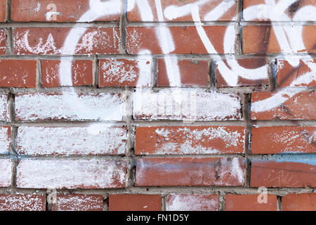 Abstract frammento graffiti su un vecchio rosso urbano muro di mattoni Foto Stock