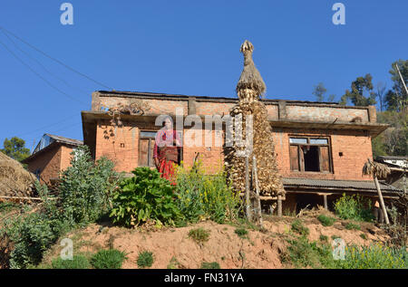 Donna di fronte a casa sua, nel villaggio di Kushadevi, Valle di Kathmandu, Nepal Foto Stock