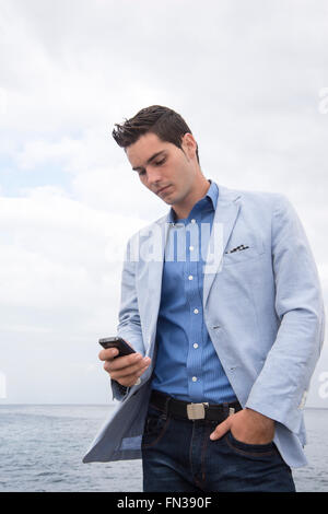 Giovane uomo latino utilizzando il telefono cellulare Foto Stock