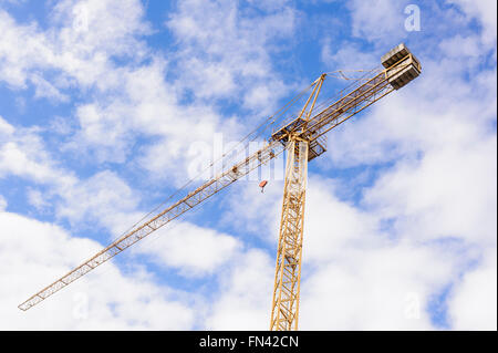 Giallo gru industriali lavorando sul sito di costruzione contro il cielo blu Foto Stock