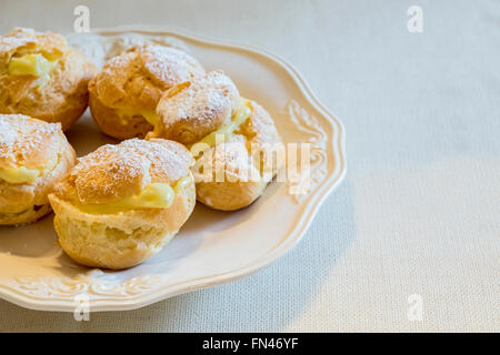 In casa bignè su una piastra bianca. Foto Stock
