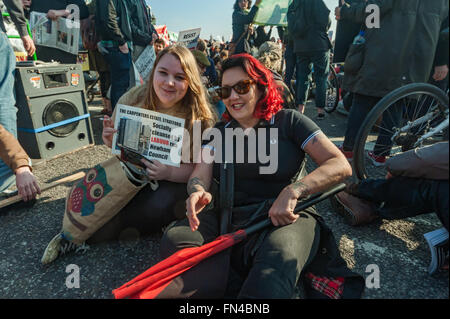 Londra, Regno Unito. 13 marzo, 2016. Jasmin pietra della messa a fuoco E15 e Lisa Mckenzie della guerra di classe presso il sit-in giù il blocco Westminster Bridge in segno di protesta contro l'alloggiamento e la pianificazione di Bill. Jasmin detiene un poster di falegnami station wagon, Stratford, socialmente purificati mediante esecuzione del lavoro Newham consiglio. Peter Marshall / Alamy Live News Foto Stock