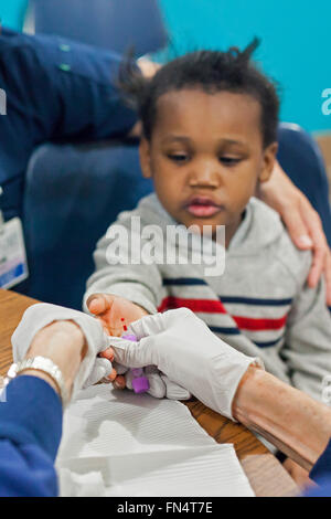 Selce, Michigan - un volontario infermiere raccoglie un campione di sangue da Maylaysia Valsin-Cooley, 3, per eseguire il test in caso di esposizione al piombo. Foto Stock