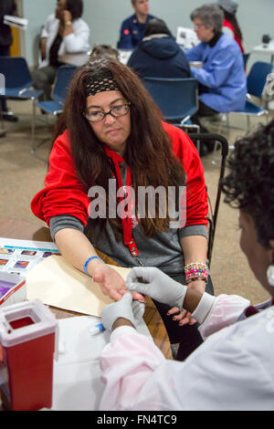 Selce, Michigan - un volontario infermiere raccoglie un campione di sangue da Michele Fiebecker alla prova per esposizione al piombo. Foto Stock