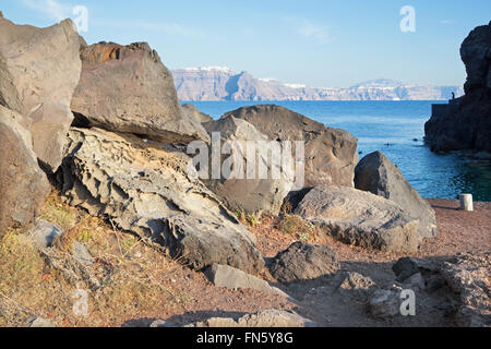 Santorini - il look di caldera tra i massi di pietra pomice con la Skyros ans Imerovigili in background. Foto Stock