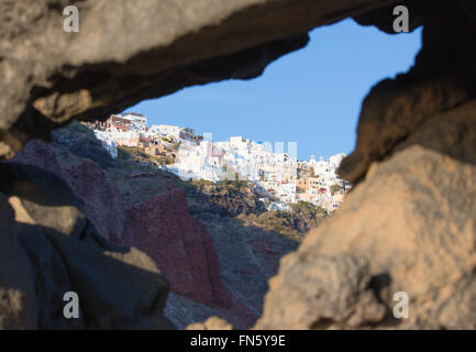 Santorini - il look di Oia attraverso i massi di pietra pomice. Foto Stock