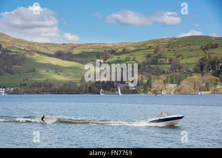 Rachael Oakden e famiglia, marito Luciano, e i figli Arthur (arancione in alto) e Henry (la più piccola e la più giovane) Godetevi il percorso ciclabile lungo la sponda occidentale del lago di Windermere nel Lake District dopo biciclette a noleggio da bassa Wray campeggio. Nella foto qui - una vista sul lago di Windermere con acqua sciatore Foto Stock