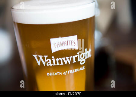 Una pinta di birra Wainwrights in un rettilineo di pinta di vetro Foto Stock