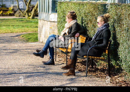 Lund, Svezia - 12 Marzo 2016: persone sconosciute in appoggio su una panchina nel parco godendo la primavera sole. La aprire pubblicamente unive Foto Stock