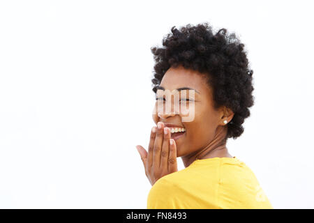 Ritratto di felice donna africana che copre la bocca e ridendo contro uno sfondo bianco Foto Stock