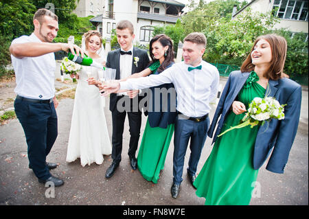 Groomsman e damigella bevendo champagne sul party di nozze Foto Stock