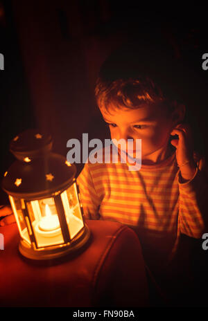 Ragazzo che guarda alla notte candela Foto Stock