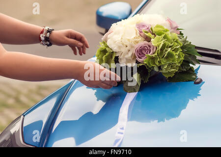 Bouquet di nozze su un cofano per auto Foto Stock