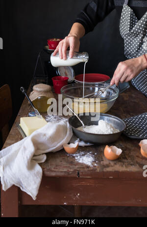 Donna versando il latte in una ciotola Foto Stock