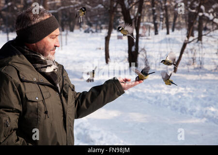 L'uomo alimentazione di un uccello in inverno, Bulgaria Foto Stock