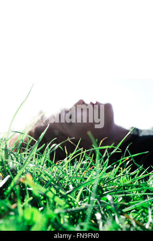 Donna sdraiata sull'erba Foto Stock