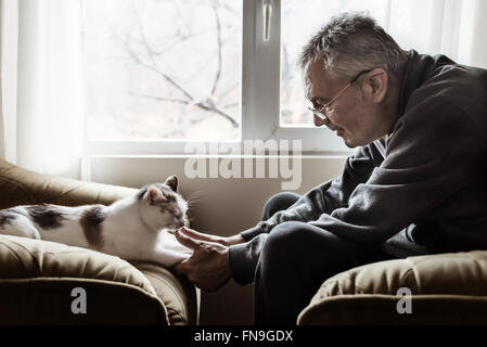 Uomo con gatto zampe Foto Stock