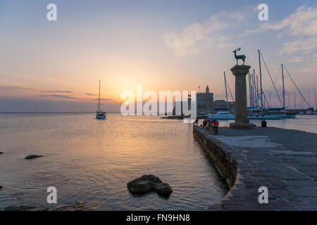 La città di Rodi, rodi, Egeo Meridionale, Grecia. Vista attraverso l'ingresso al porto di Mandraki, sunrise, yacht di uscire in mare. Foto Stock