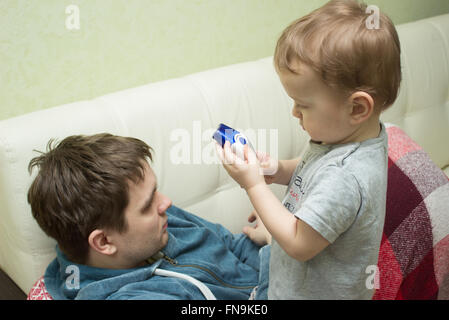 Littke boy cheking padre la temperatura Foto Stock