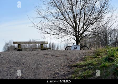 Una bicicletta pubblicità un cane a piedi servizio è legato ad un albero vicino alle rive del fiume Mersey in didsbury, South Manchester Foto Stock
