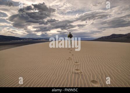Uomo che cammina nelle dune di eureka, Death Valley National Park, California, Stati Uniti Foto Stock