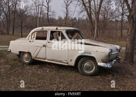 Un vecchio rotto auto sovietica in sottili ambiente forestale Foto Stock